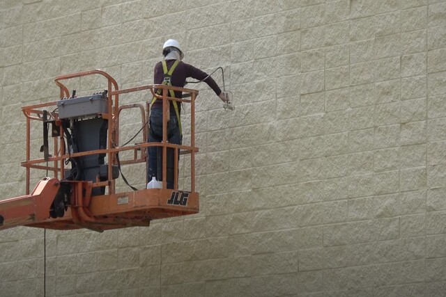 Glendale Commercial Painting worker on a forklift machine painting a wall