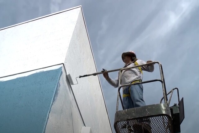 Glendale Exterior Painting Service employee roller painting a wall up high